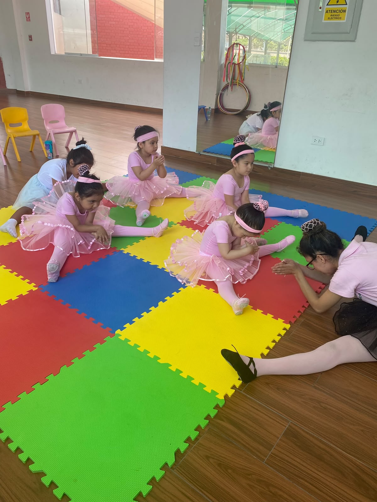 Niñas en clase de ballet sentadas en el suelo